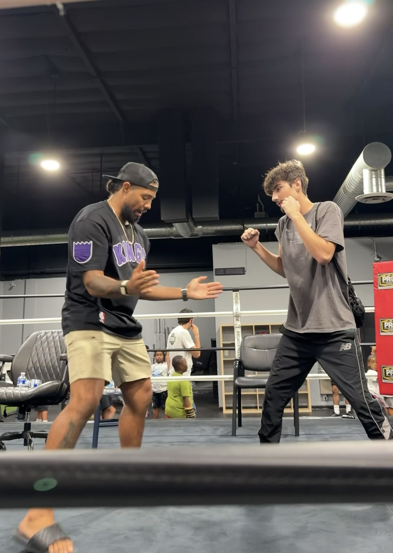 Max demonstrating a boxing stance with a young participant