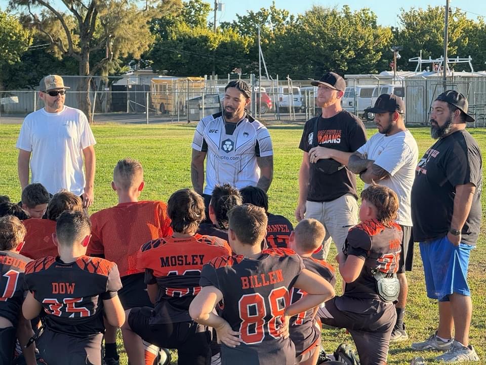 Max and coaches talking with youth football players